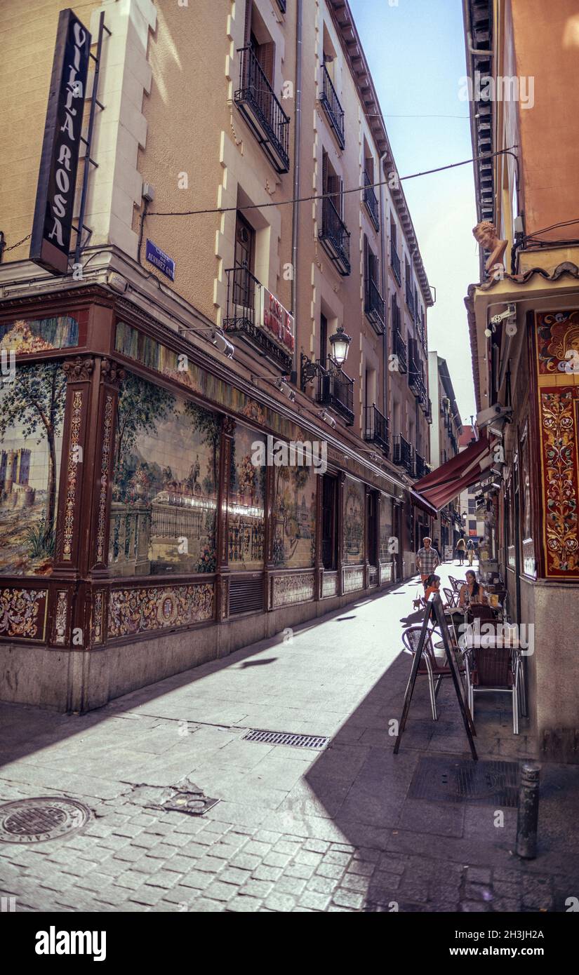 MADRID, SPAIN - APRIL 26: Old narrow street with few cafe in April 26, 2013 in Madrid, Spain. It is old centre of capital city Stock Photo