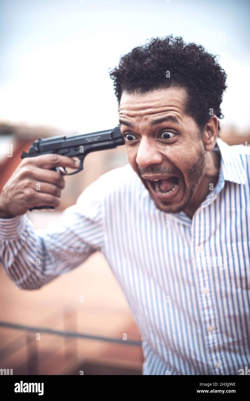 Confident attractive mulatto man with a gun Stock Photo