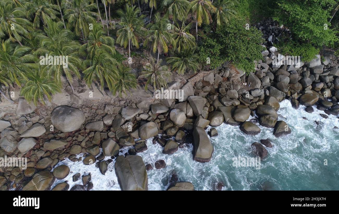 Aerial top view of sea waves hitting rocks on the beach in Phuket Stock Photo