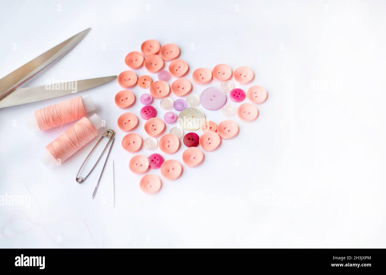 Sewing accessories. Button heart shape. Spools of thread. Tailor's