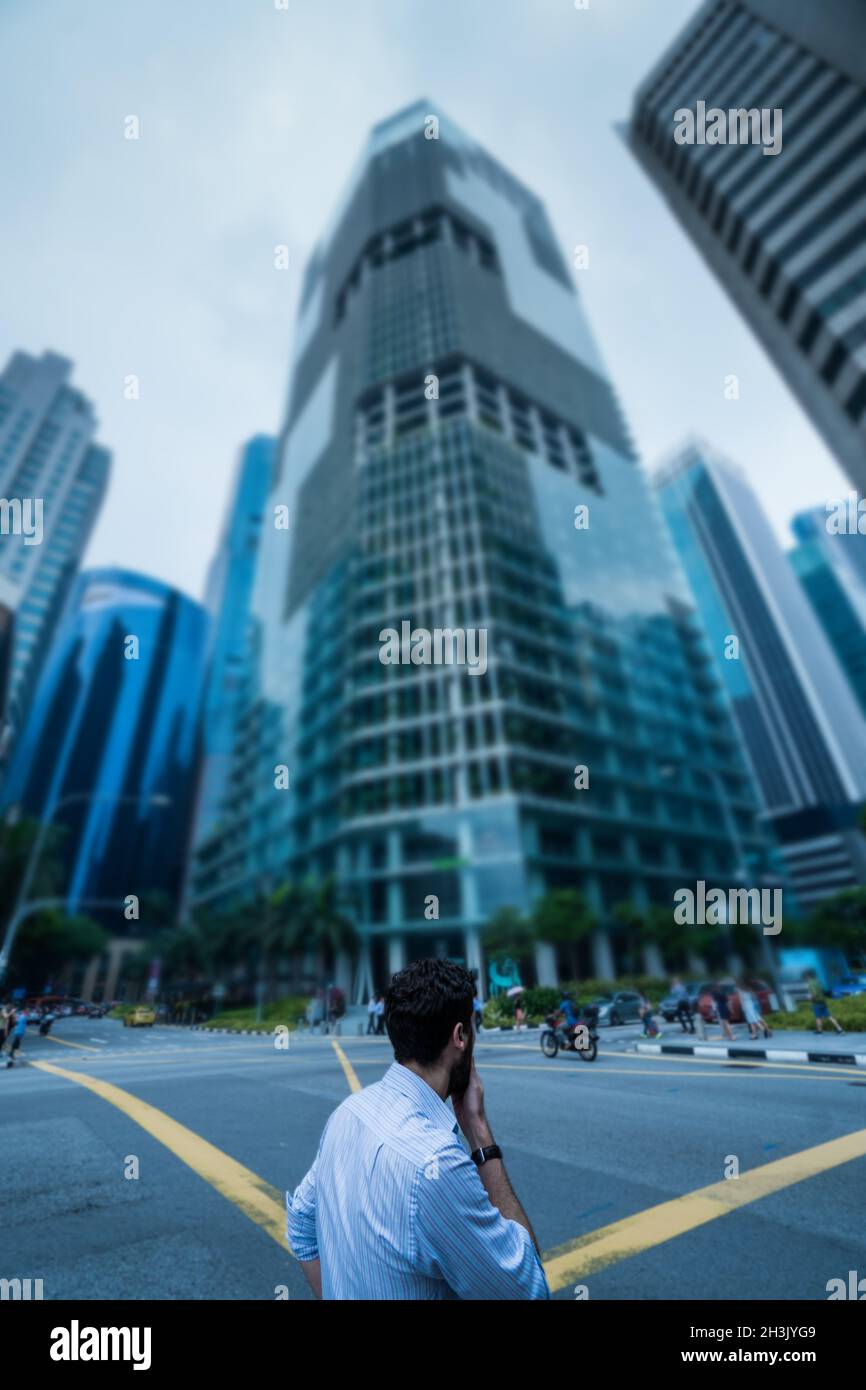 Man standing on the street against modern skycrapers Stock Photo