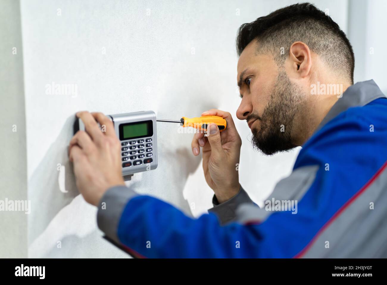Technician Installing Security Access Alarm System Control Stock Photo