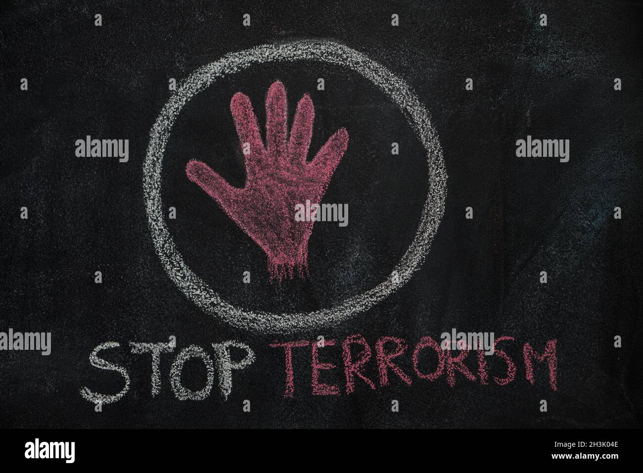 Red hand shape and stop terrorism text in the circle on black chalkboard Stock Photo