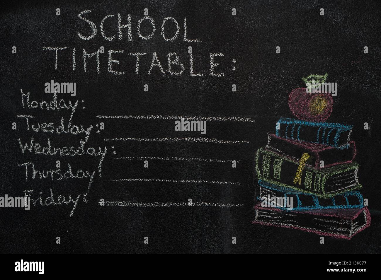 School timetable and stack of books with apple drawn on black chalkboard Stock Photo