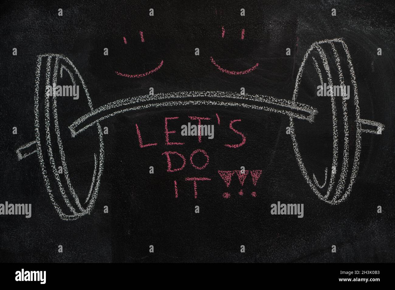 Barbell and Let's do it text on black chalkboard Stock Photo