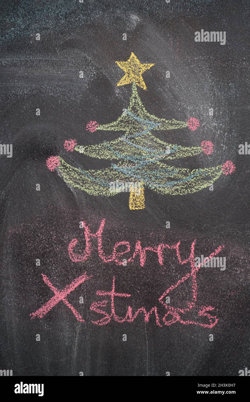 Christmas tree with Merry Xmas writing on black chalkboard Stock Photo