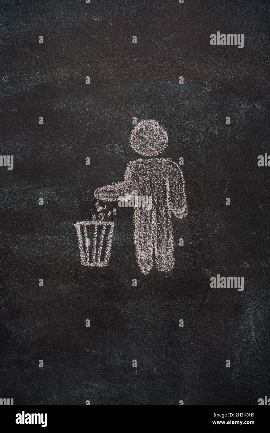 Trash bin with human symbol on black chalkboard Stock Photo
