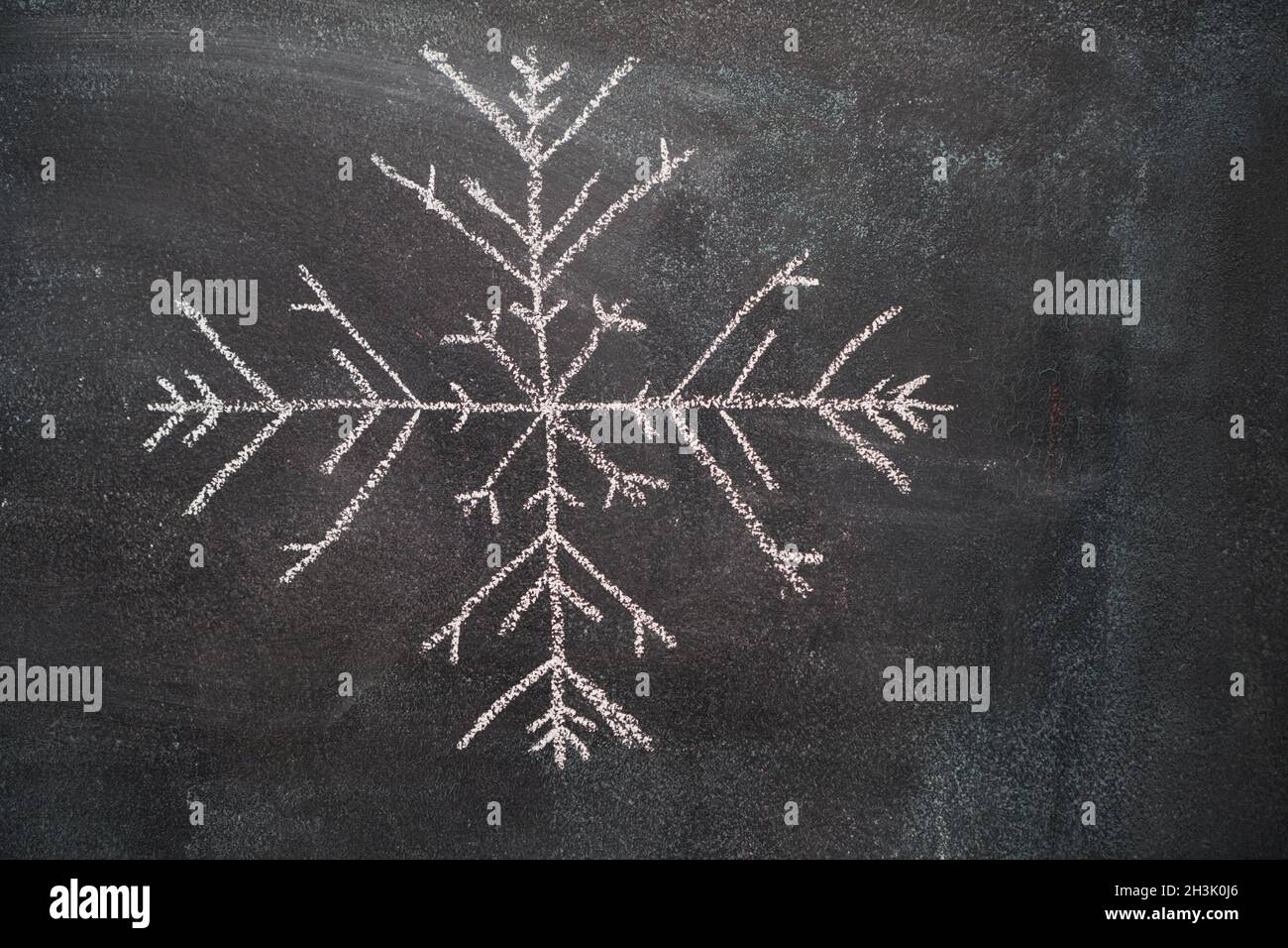 Big snowflake on black chalkboard Stock Photo