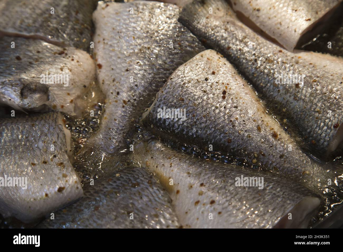Cooking fish, deep fried fishes in hot oil in a frying pan Stock Photo