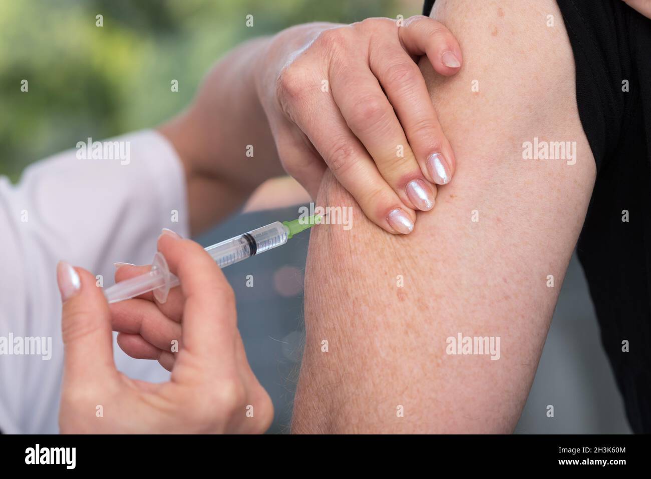 Doctor giving an injection to a patient Stock Photo - Alamy