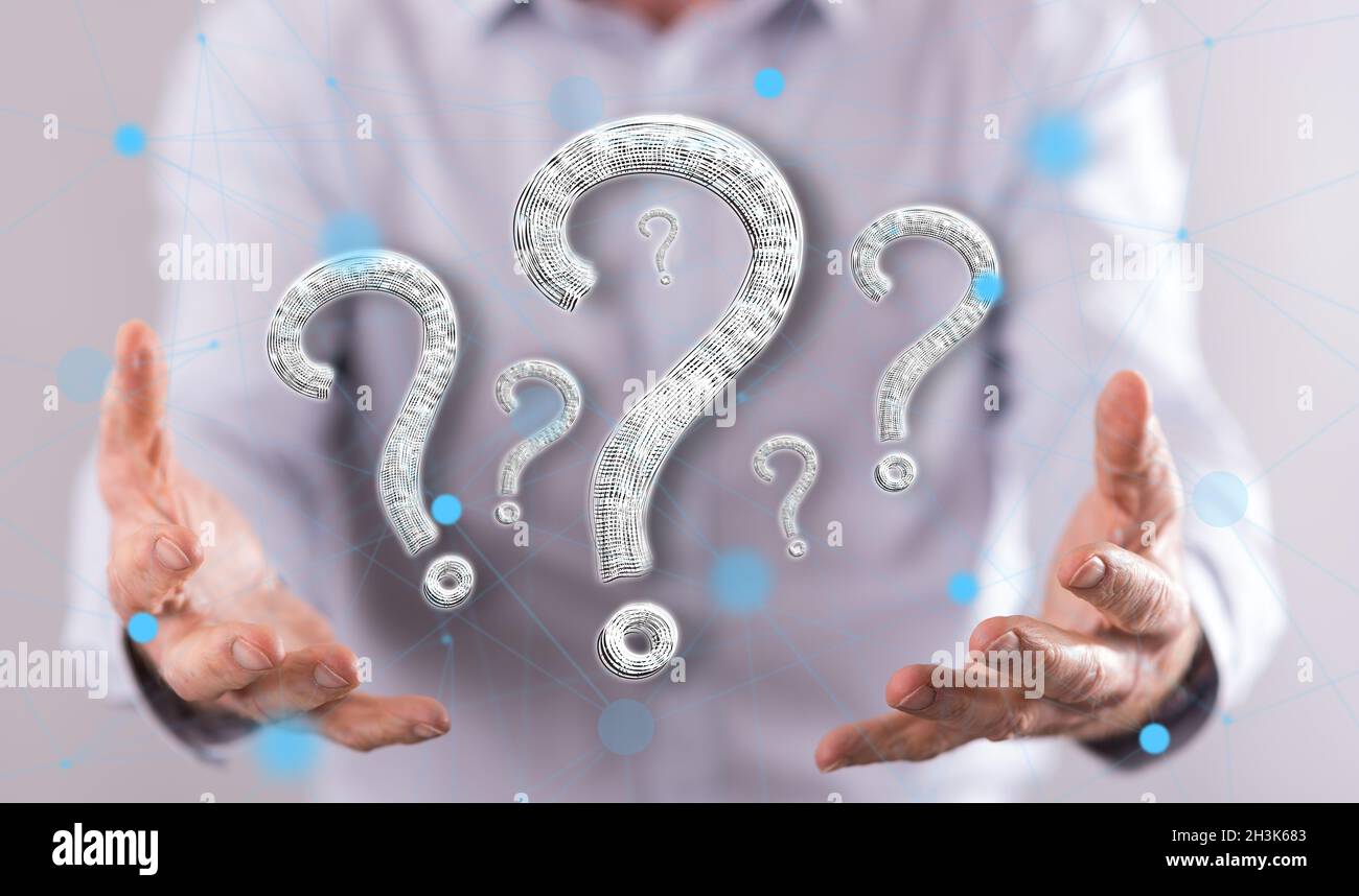 Question concept above the hands of a man in background Stock Photo