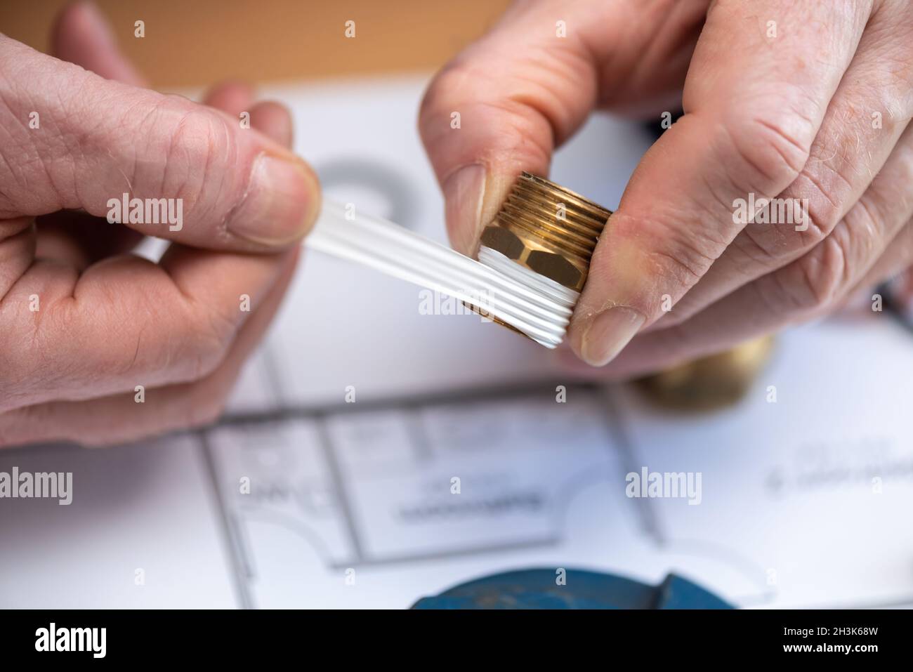 Plumber putting seal tape on a thread of a plumbing fitting Stock Photo Alamy