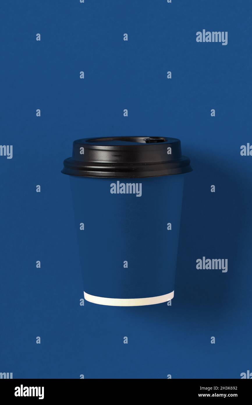 Cardboard blue coffee cup on classic blue background top view Stock ...