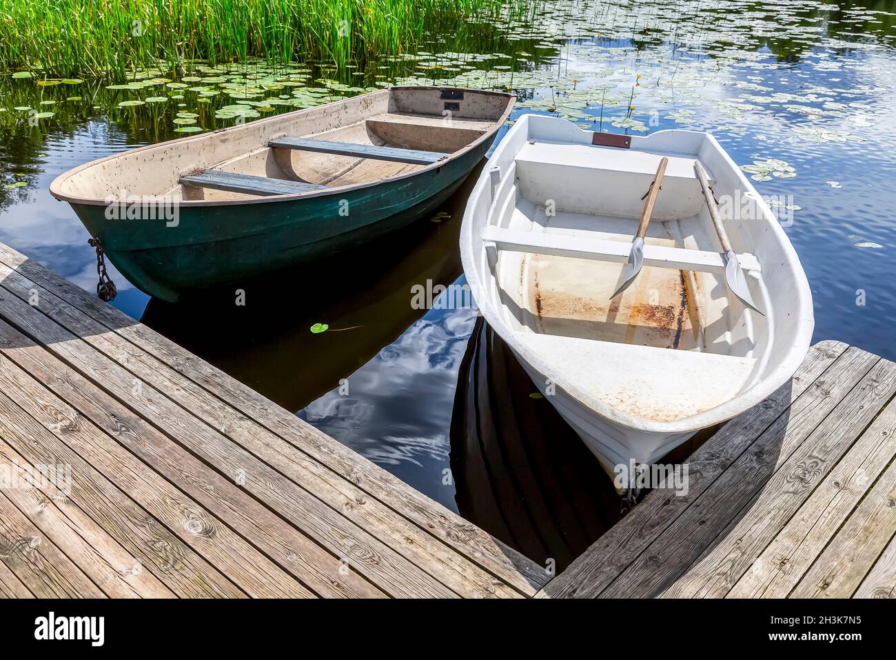 Old plastic fishing boats on the bank of the lake in summer sunny day Stock  Photo - Alamy