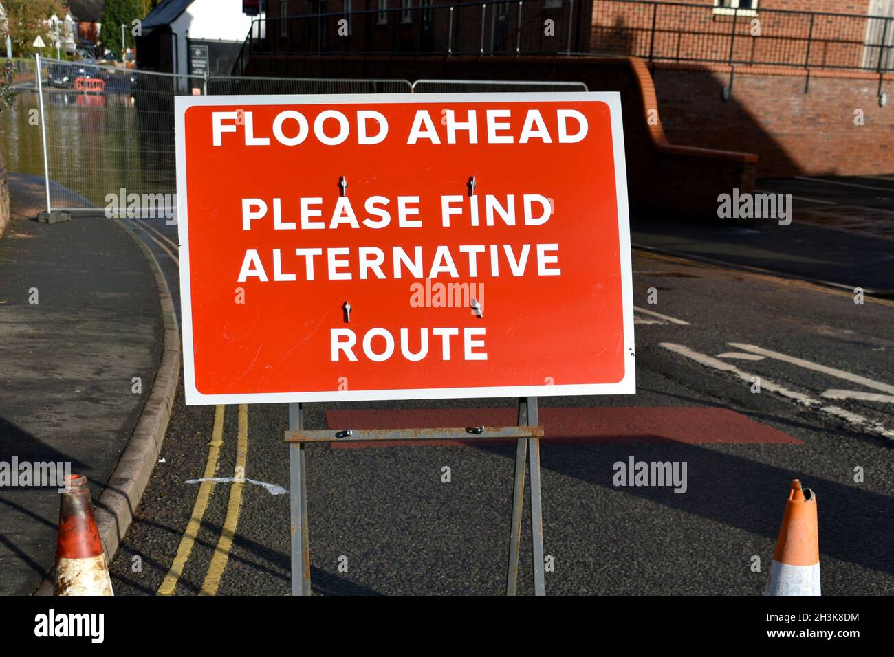close up of red and white metal sign. advising Flood Ahead, please find alternative route due to waters of a swollen river in winter Stock Photo