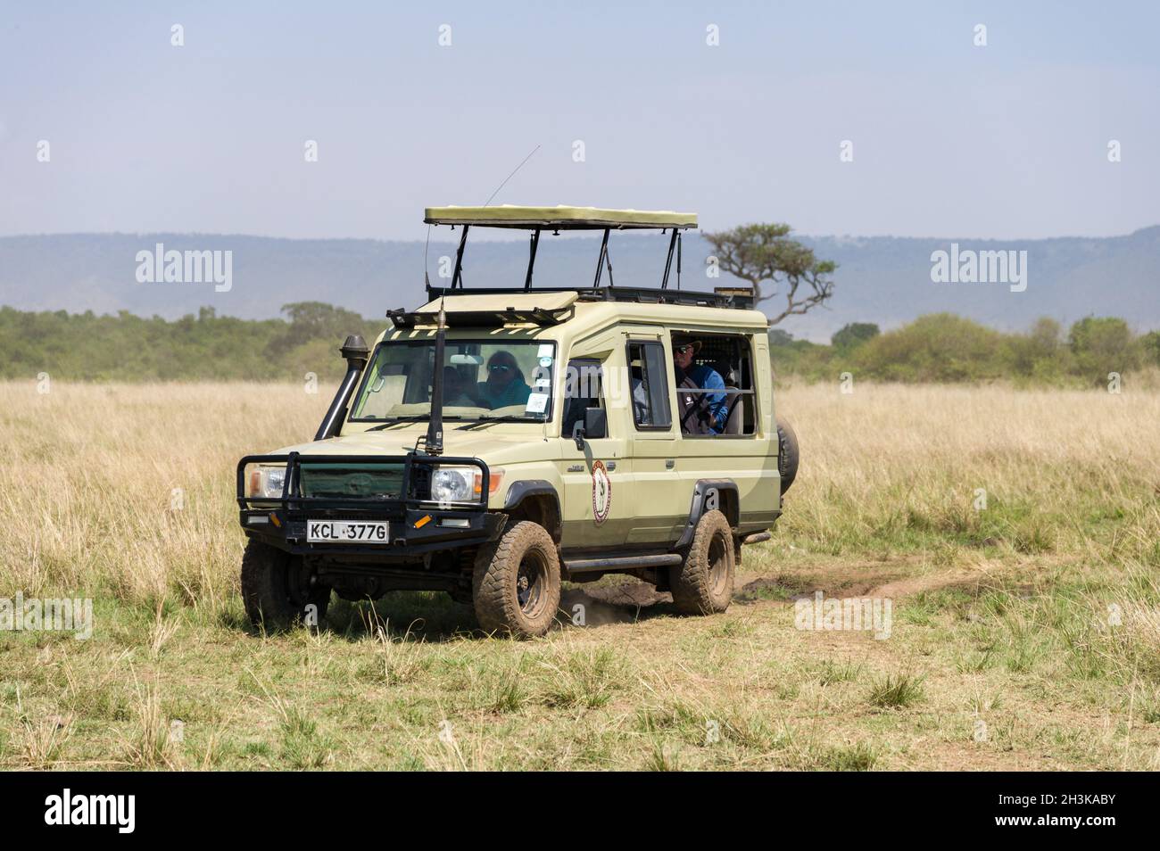 Tourists sat waiting in an open 4x4 Toyota Landcruiser, Masai Mara, Kenya Stock Photo