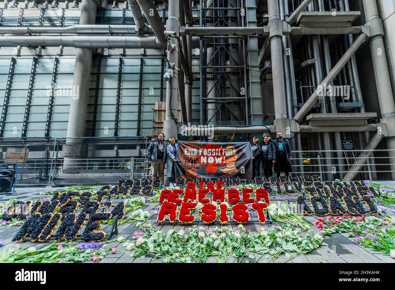 London, UK. 29 Oct 2021. Pacific Climate Warriors lay floral tributes to those in danger from climate change in their home islands - Protesters from Coal Action Network set up a climate justice memorial at Lloyd's of London to remember communities on the front lines of climate breakdown who are directly impacted by harmful projects and climate impacts. The memorial involved hundreds of flowers and floral wreaths being laid outside. Flowers with over 600 individual messages from people across the UK were handed out to staff going in and out of the Lloyd's building. Credit: Guy Bell/Alamy Live N Stock Photo