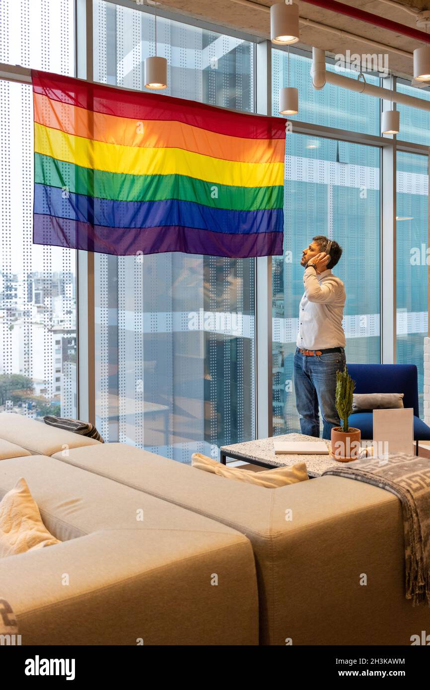 Handsome man, contemplating the flag representing the LGBT community Stock Photo