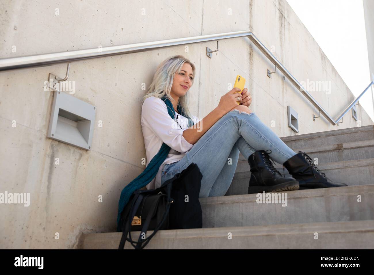 a professional young blonde woman using a smartphone. selfie Stock Photo