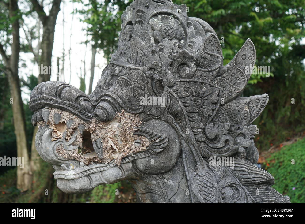 Traditional hindu statue of dragon's head in the garden in Bali Stock Photo