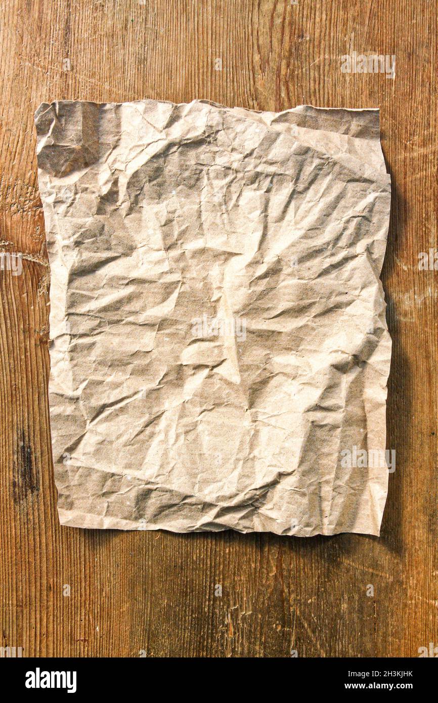 Crumpled empty paper sheet on wooden table Stock Photo