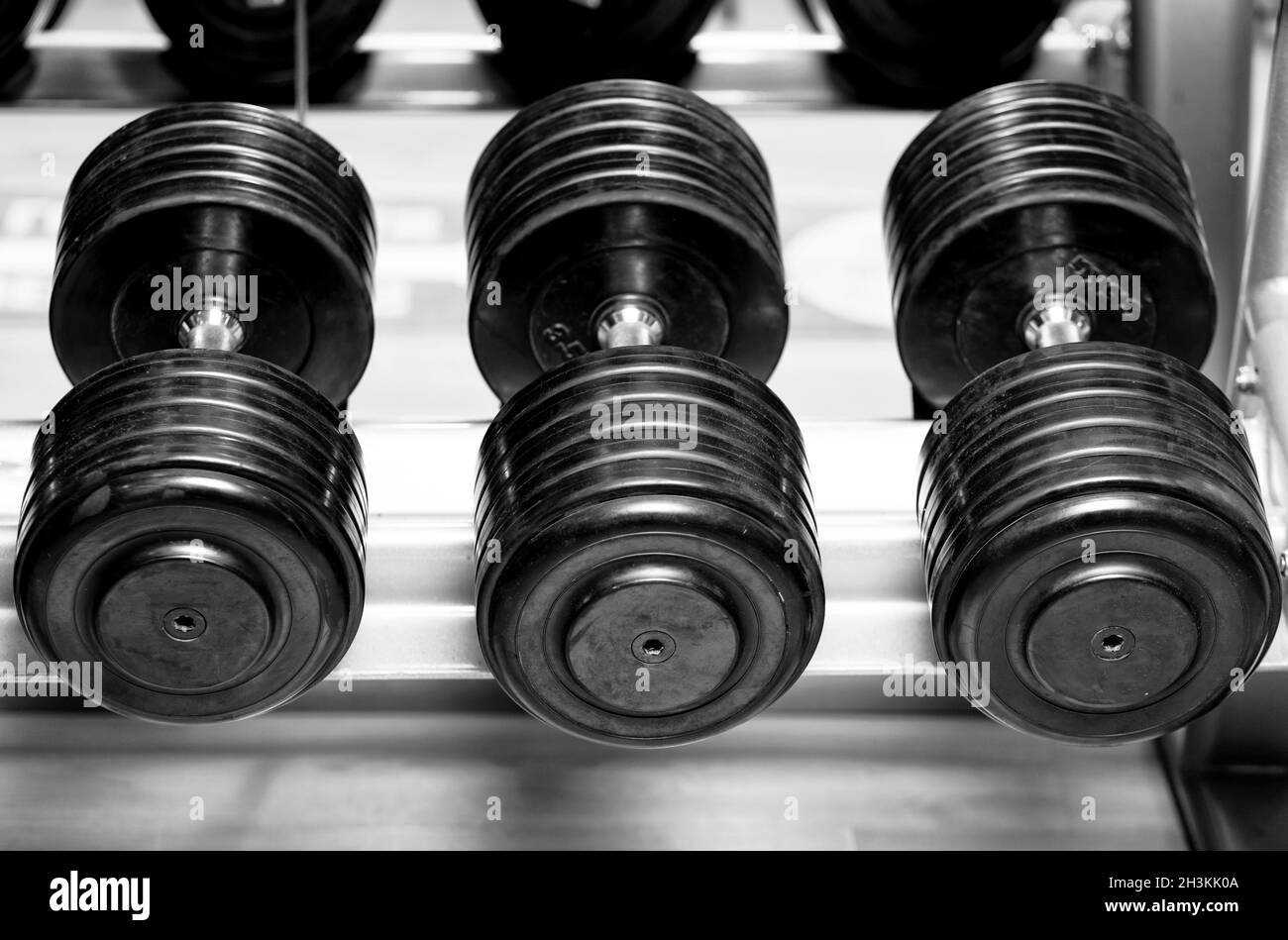 Different sizes and weights of dumbbell free weights at a gym in black