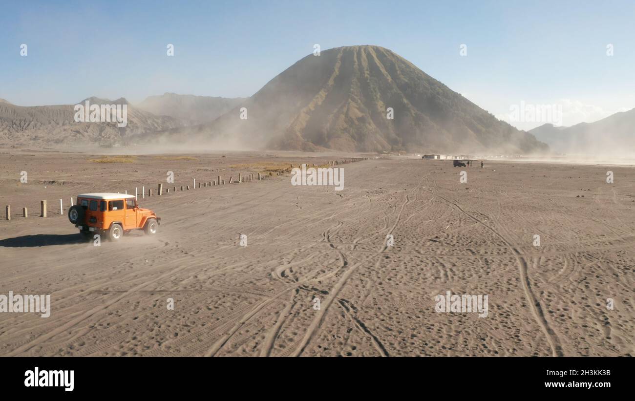 Cinematic shot aerial view of tour jeep cruise at beautiful Mount Bromo volcano with desert in East Java Stock Photo