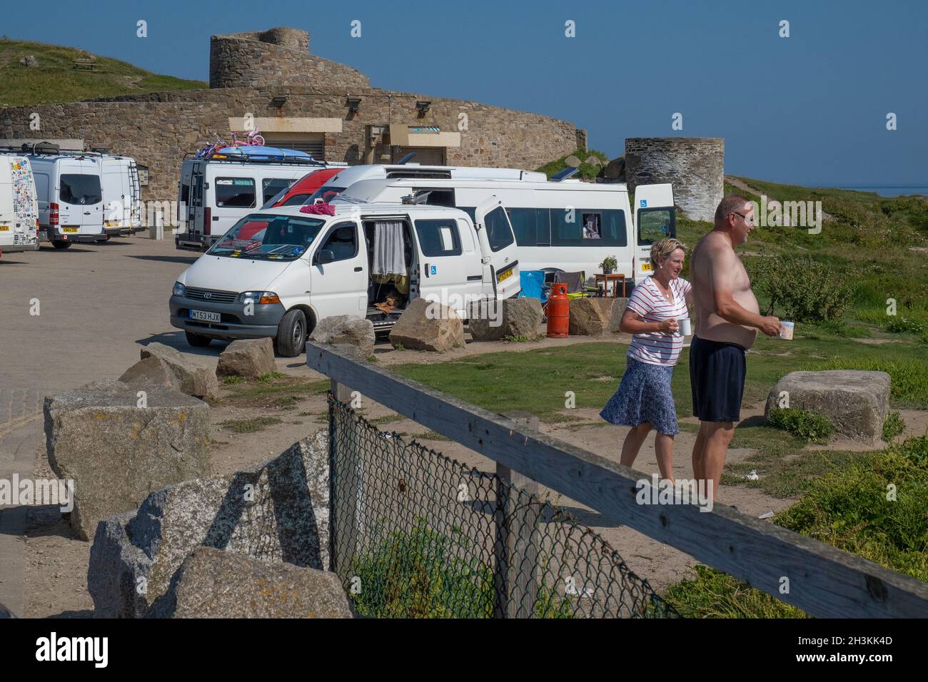 Holidaymakers and their campervans staying in Little Fistral car park in Newquay in Cornwall. Stock Photo