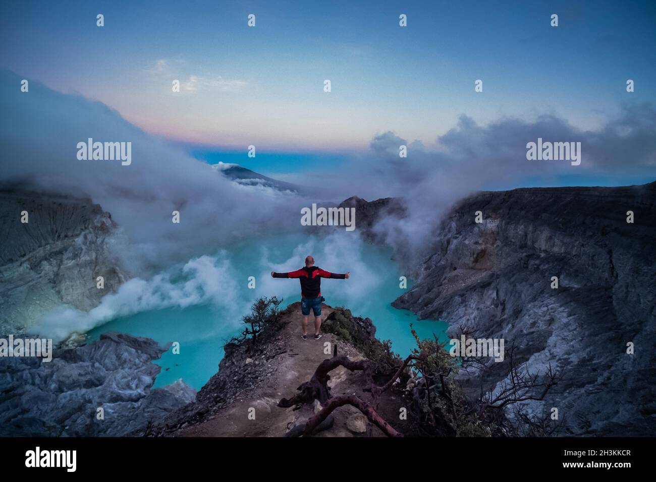 Man traveler standing on edge of crater Ijen volcano with colorful sky at  morning Stock Photo - Alamy