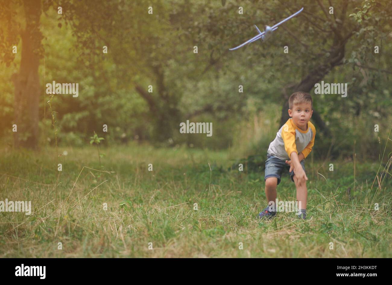 A Boy Flying A Blue Toy Airplane Stock Photo