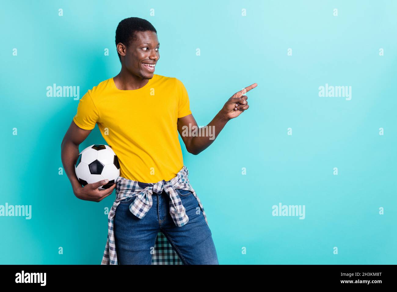 Profile photo of cool brunette hairdo young man hold ball point look empty space wear yellow t-shirt isolated on cyan color background Stock Photo