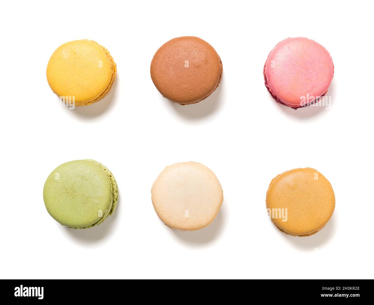 Variety of pastel colored macarons pastry, isolated on white background. Flat lay high angle view of delicious french cookies. Stock Photo