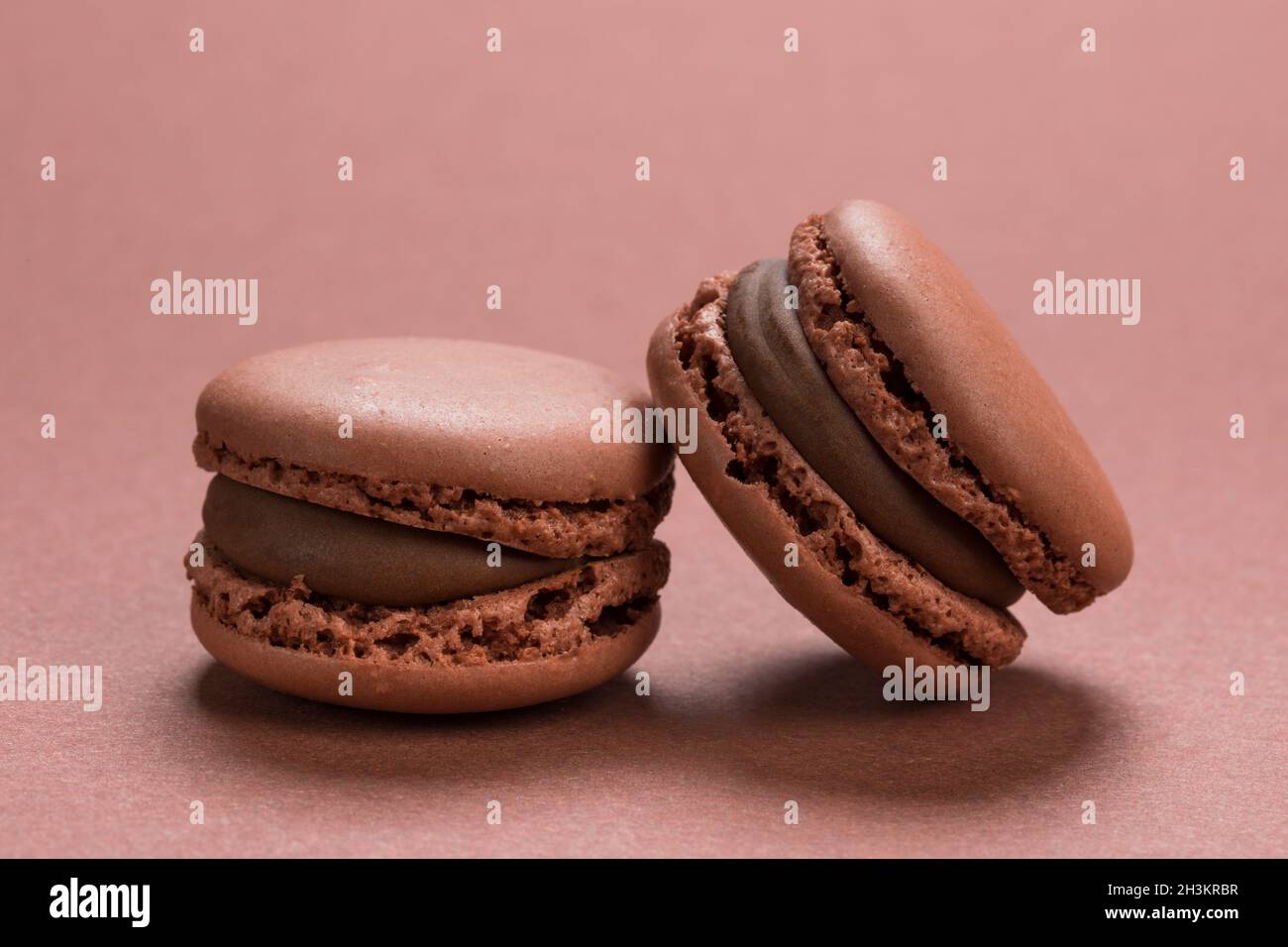 Chocolate flavor French macaron cookies closeup on background of a similar brown colour Stock Photo