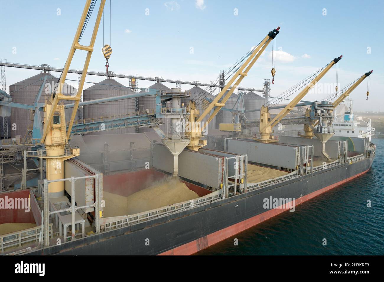 Loading grain into holds of sea cargo vessel through an automatic line