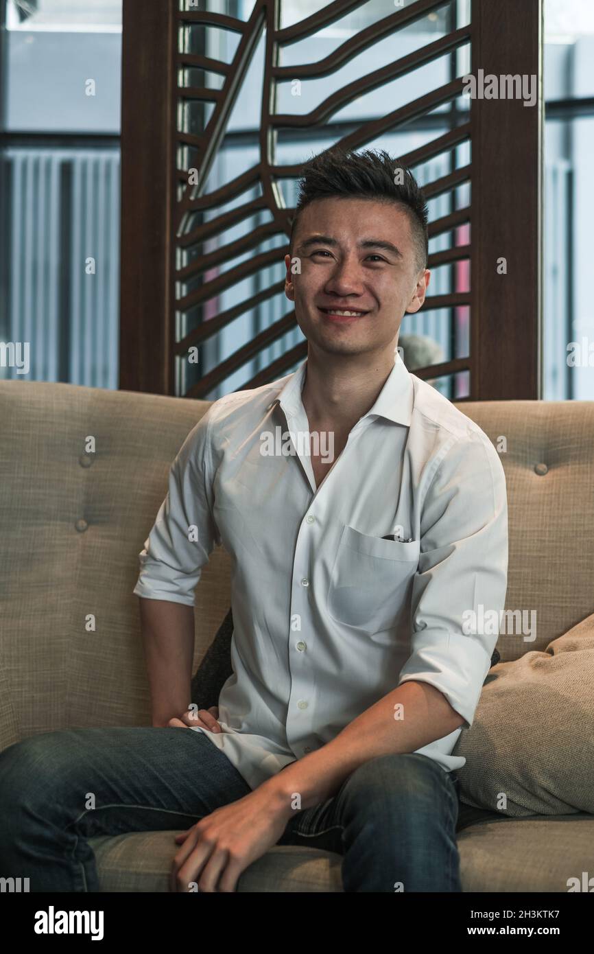 Asian young handsome man sitting in coffee shop, talking and smiling ...
