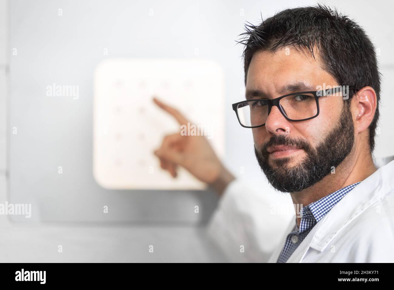 Doctor Optician With Letter Chart Conducting An Eye Test Check Stock