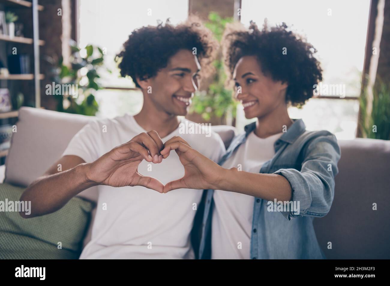 Photo of happy positive afro american wife husband sit couch fingers ...