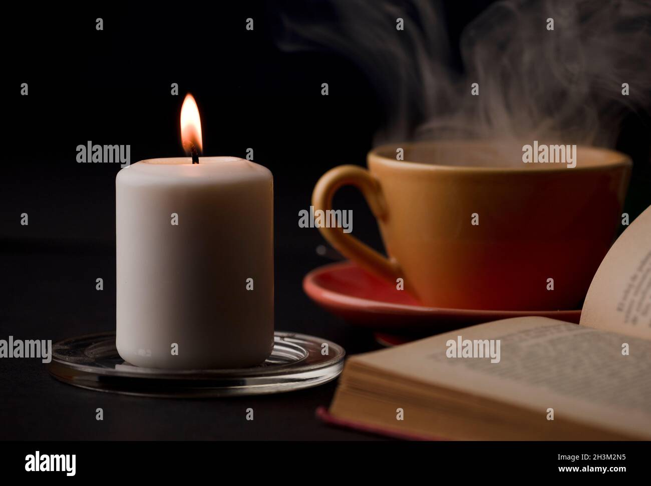 home study table with candles with flame and reading book, (focus on
