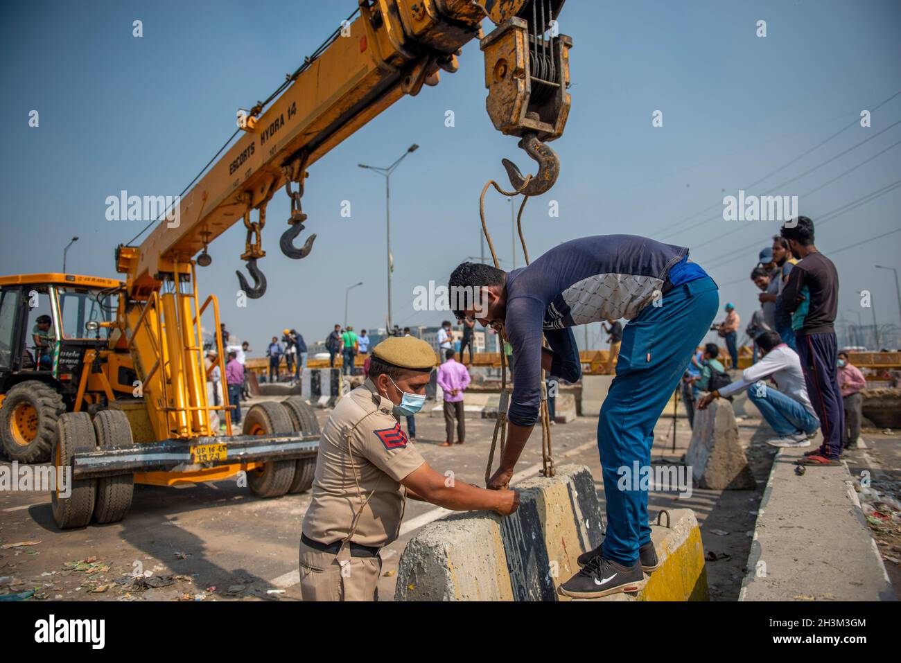 New Delhi, India. 29th Oct, 2021. Delhi Police starts removing concrete barricades with the help of an excavator machine from New Delhi-Uttar Pradesh border crossing at Ghazipur, New Delhi.Thousands of farmers have been protesting at the Ghazipur, Tikri, Singhu and borders in outer and eastern Delhi against three farm laws since last November. The blockades there were put up following the violence during the farmers' Republic Day rally. (Photo by Pradeep Gaur/SOPA Images/Sipa USA) Credit: Sipa USA/Alamy Live News Stock Photo