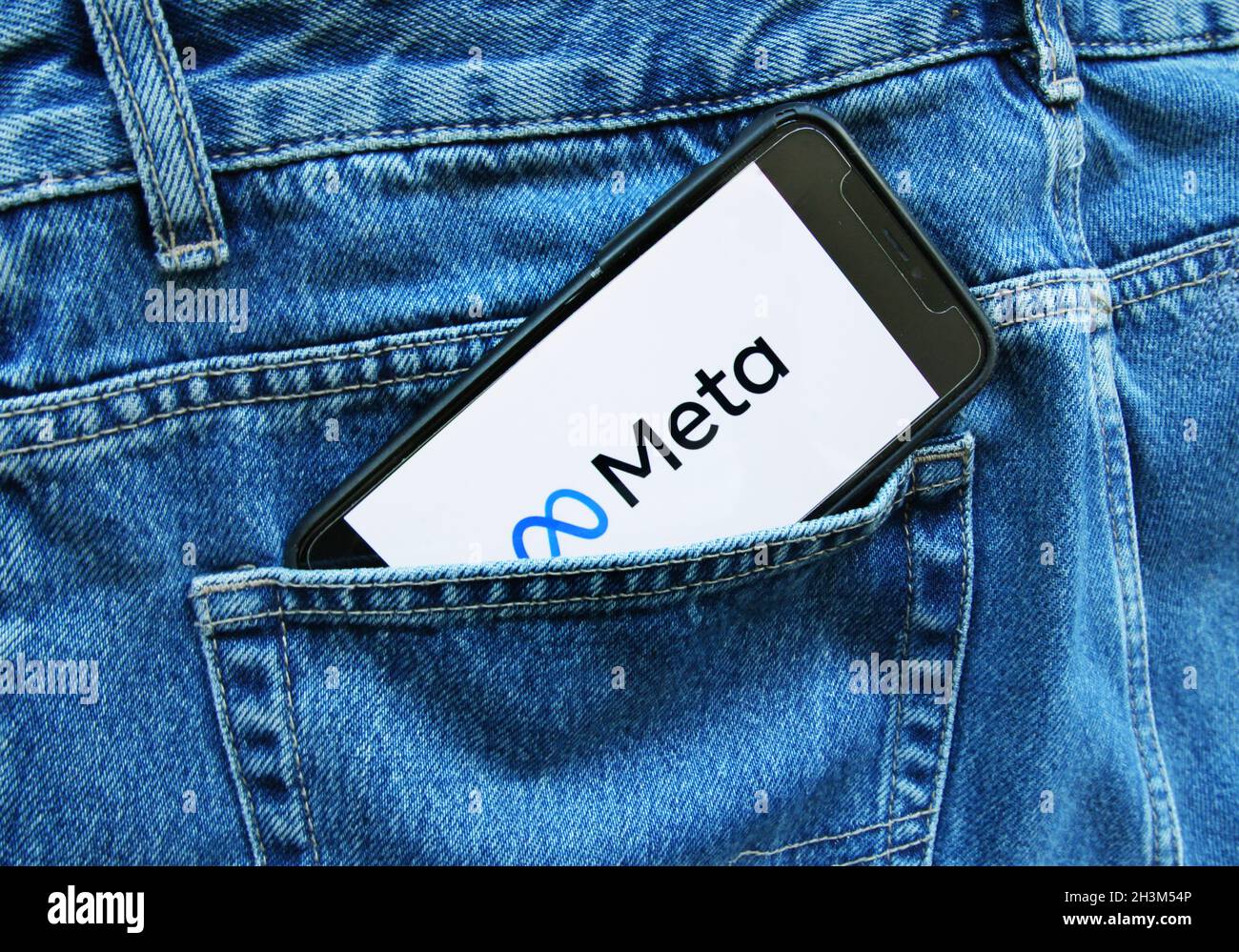 In this photo illustration an internet user hold  his smartphone in the pants pocket as displays the new logo/name Meta of the social networking of the Facebook on October 29, 2021 in Amsterdam,Netherlands. The Facebook Company's CEO Mark Zuckerberg  announced yesterday during the Facebook Connect conference, Facebook changes the name to Meta,  the change is to demarcate the company's new phase, which is focused on building a metaverse, a virtual world in which people can interact using augmented reality, virtual reality and other technologies. (Photo by Paulo Amorim/Sipa USA) Stock Photo