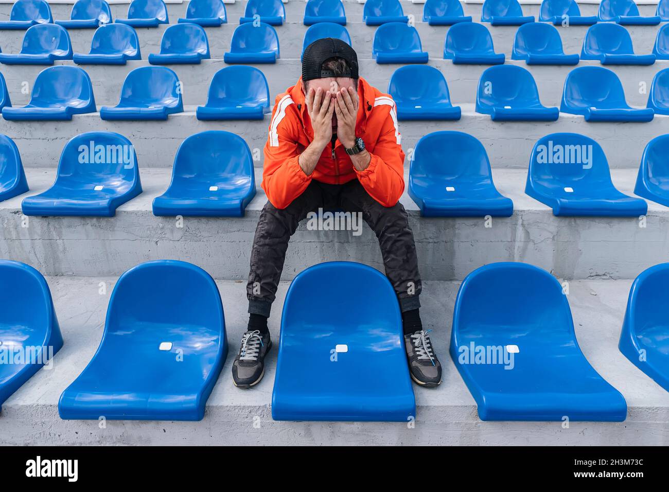 disappointed upset young fan sitting on the tribune. fan is