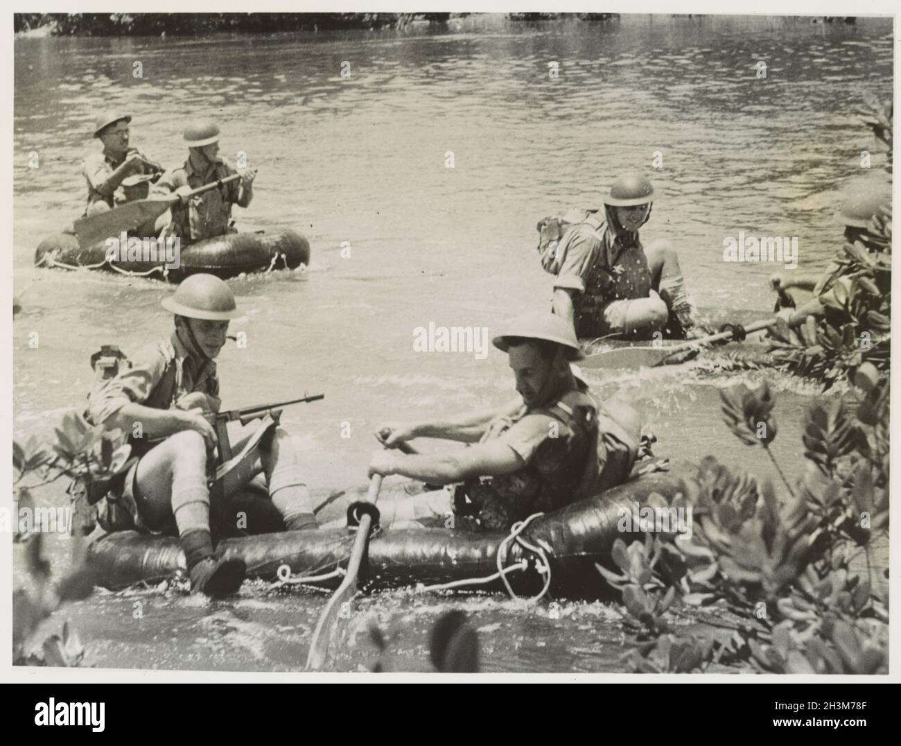 A vintage photo circa 1941 showing soldiers of the Australian Army crossing a jungle river in inflatable rubber boats during the Japanese invasion of Malaya and the fall of Singapore Stock Photo