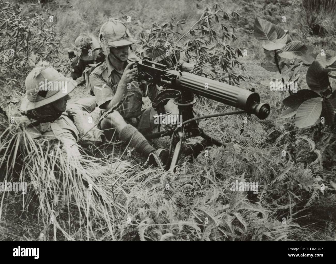 A vintage photo circa February 1942 showing soldiers of the 1st Battalion The Manchester Regiment British Army manning a vickers machine gun in the jungle during the Japanese invasion of Malaya and the fall of Singapore Stock Photo