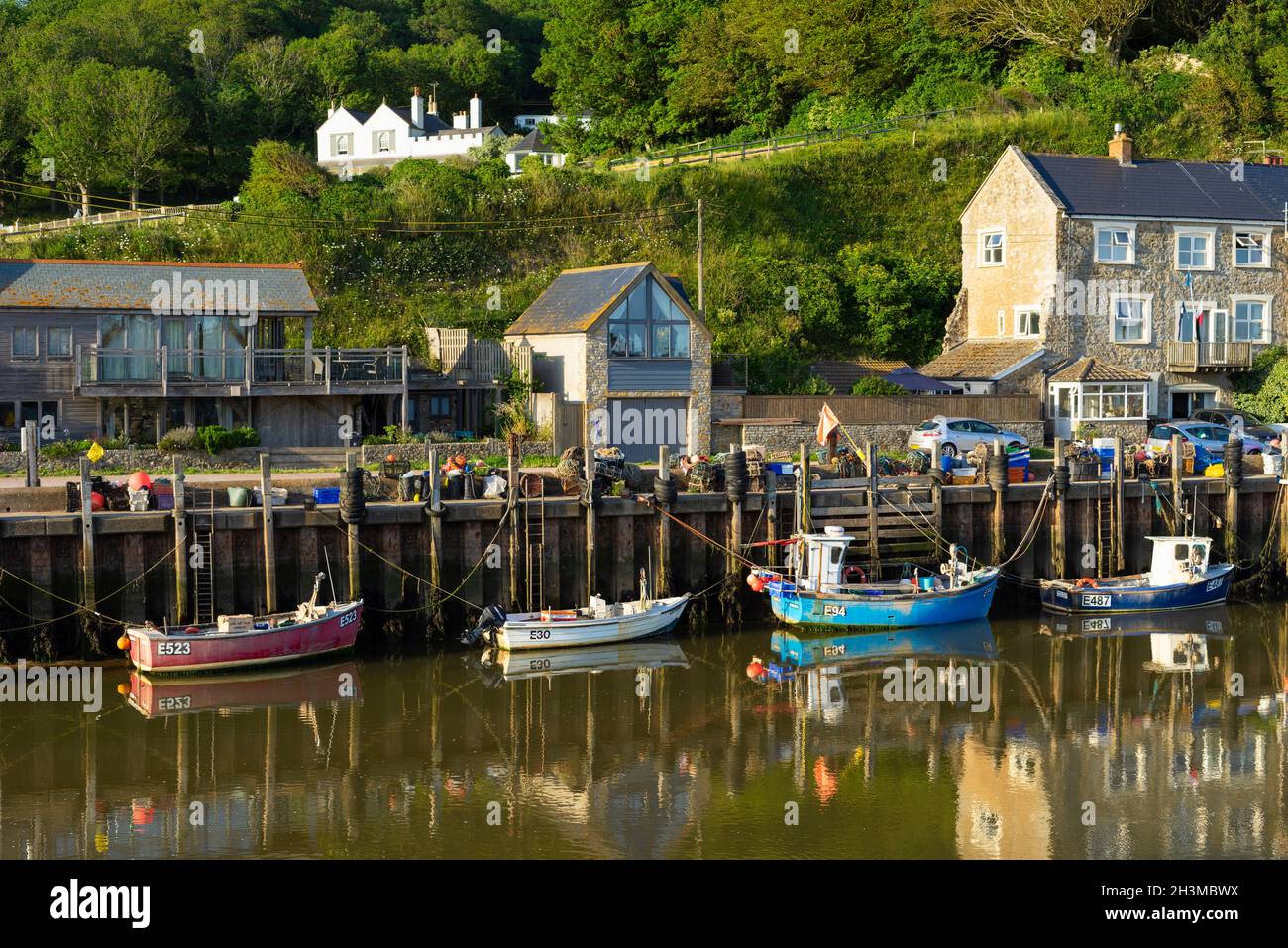 Fishing boats moored at Seaton Angling and Kayak Centre in Axmouth harbour on the River Axe at Haven Cliffs Seaton Devon England UK GB Europe Stock Photo