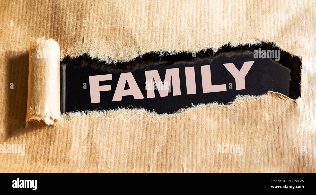 The word Family is written on brown torn paper. Stock Photo