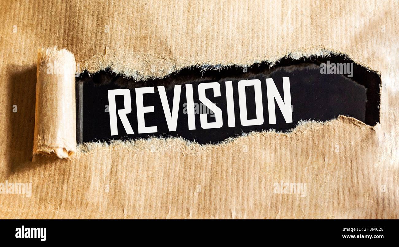 The text of the REVISION is written on a torn sheet of paper on a black background. A business concept to double-check before you start preparing for Stock Photo