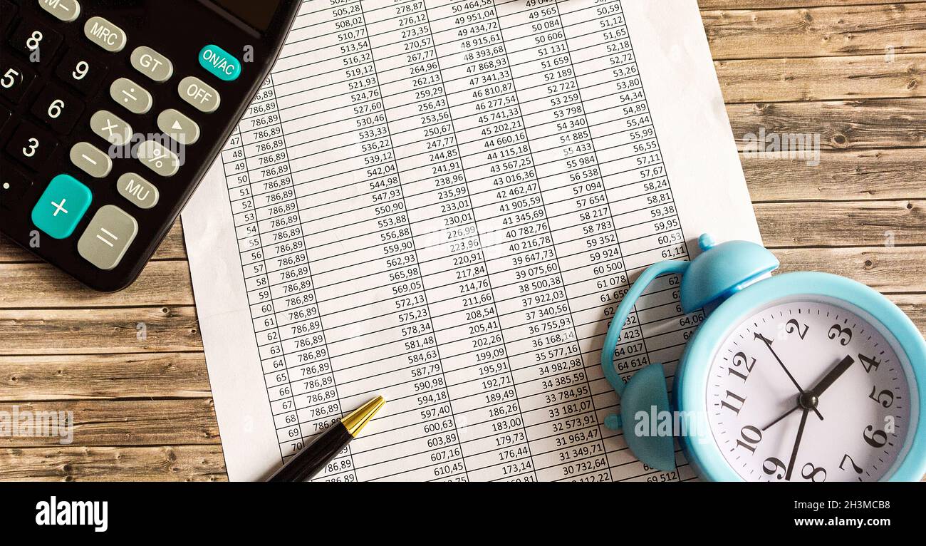 On a wooden table there is a calculator, a pen and letterheads with numbers  Stock Photo - Alamy