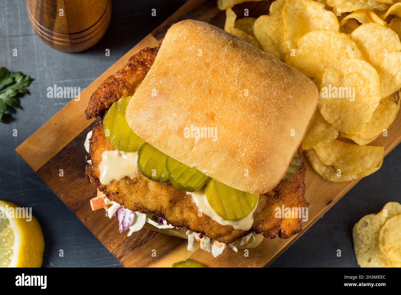 Homemade German Chicken Schnitzel Sandwich with Chips Stock Photo