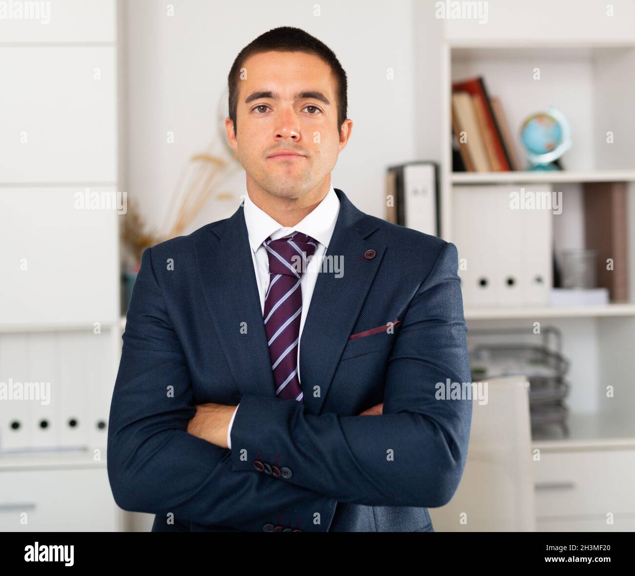 Successful businessman with arms crossed in office interior Stock Photo ...