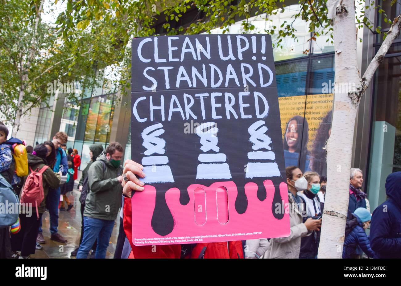 London, UK. 29th Oct, 2021. A protester holds a 'Clean Up Standard Chartered' placard during the Defund Climate Chaos demonstration.Activists gathered outside Standard Chartered in the City of London ahead of the COP26 climate change conference, calling on the bank to end all fossil fuel financing. Credit: SOPA Images Limited/Alamy Live News Stock Photo